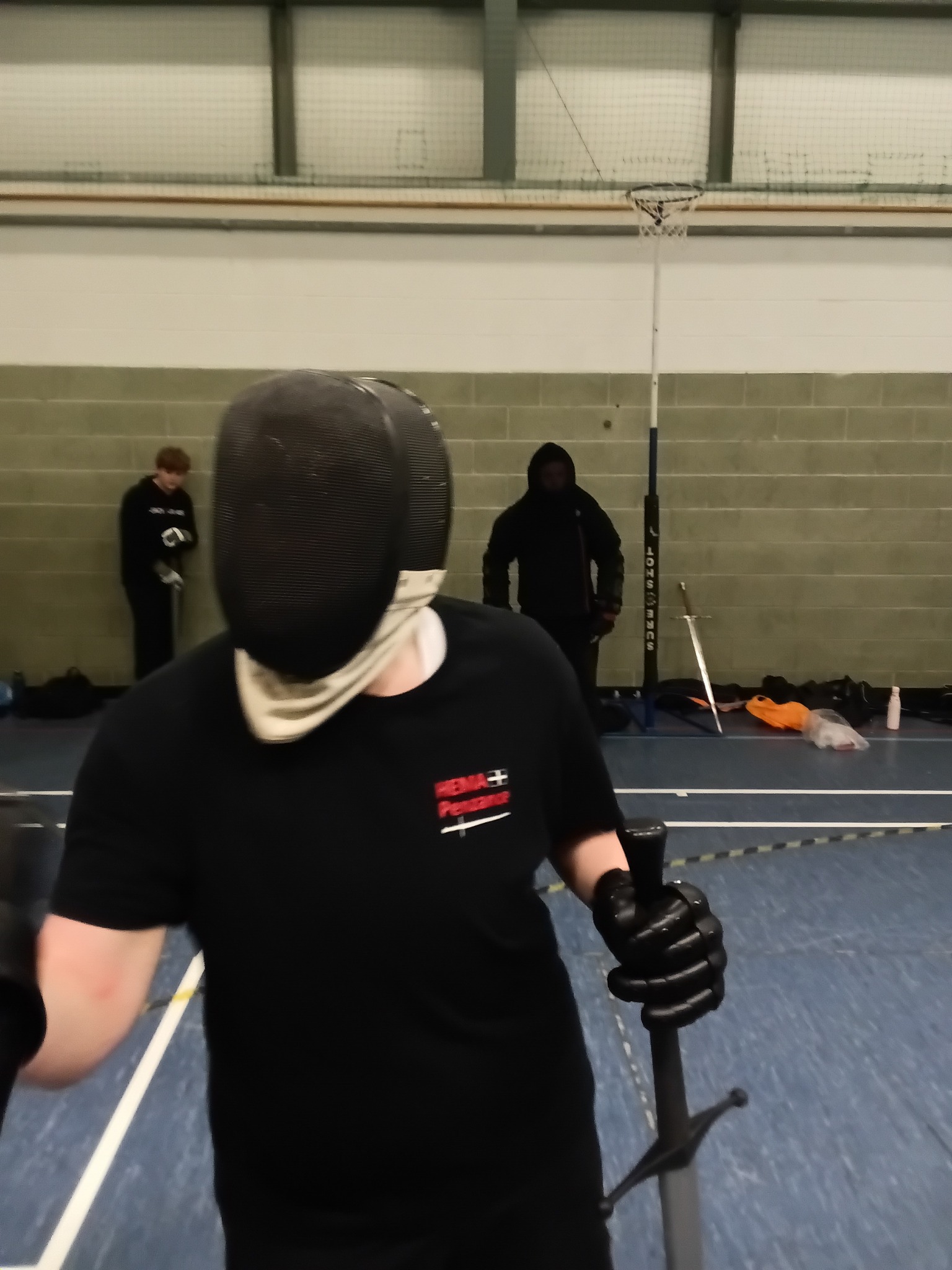 Member with fencing mask up between bouts