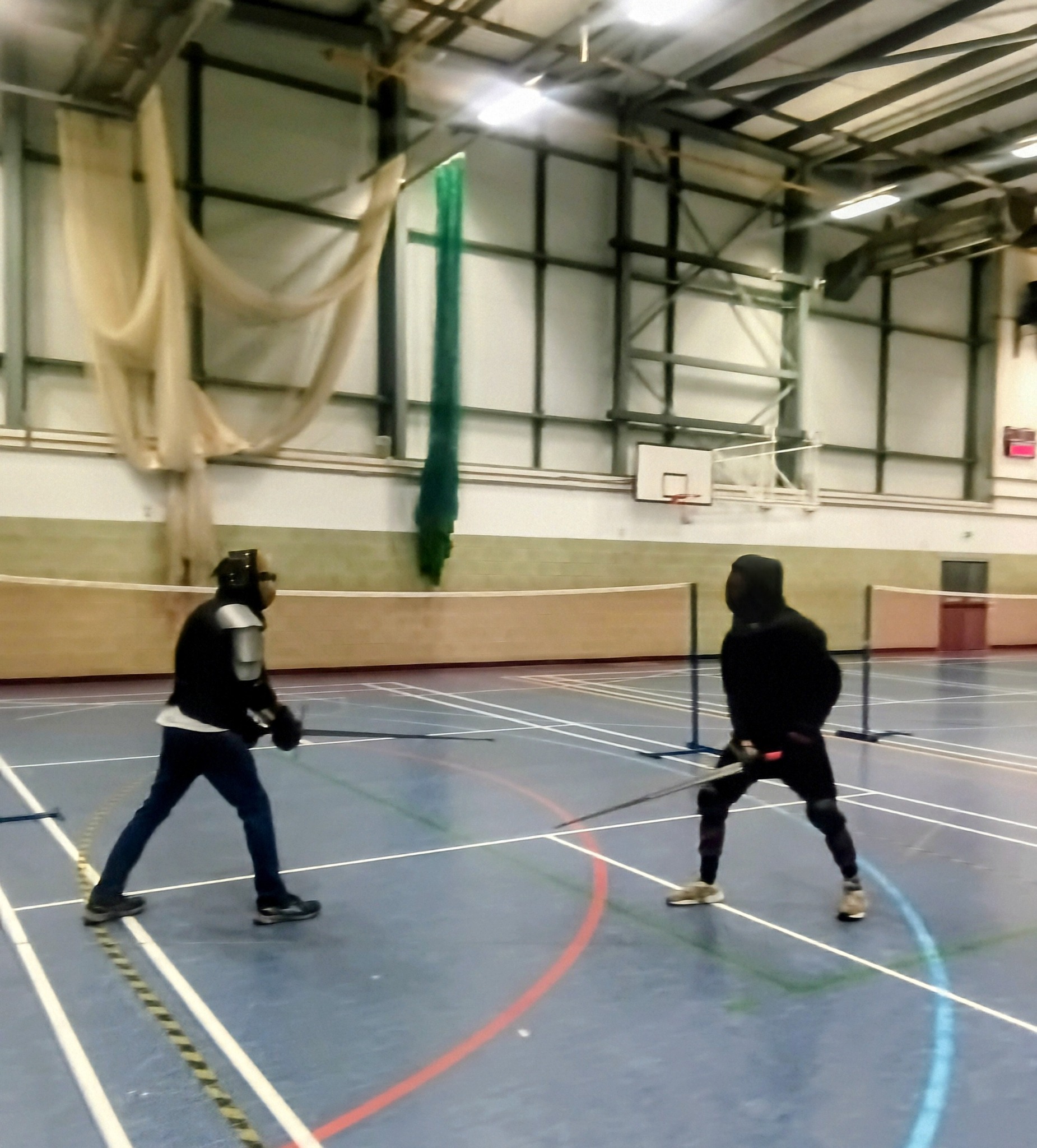 Two masked fighters at sparring distance